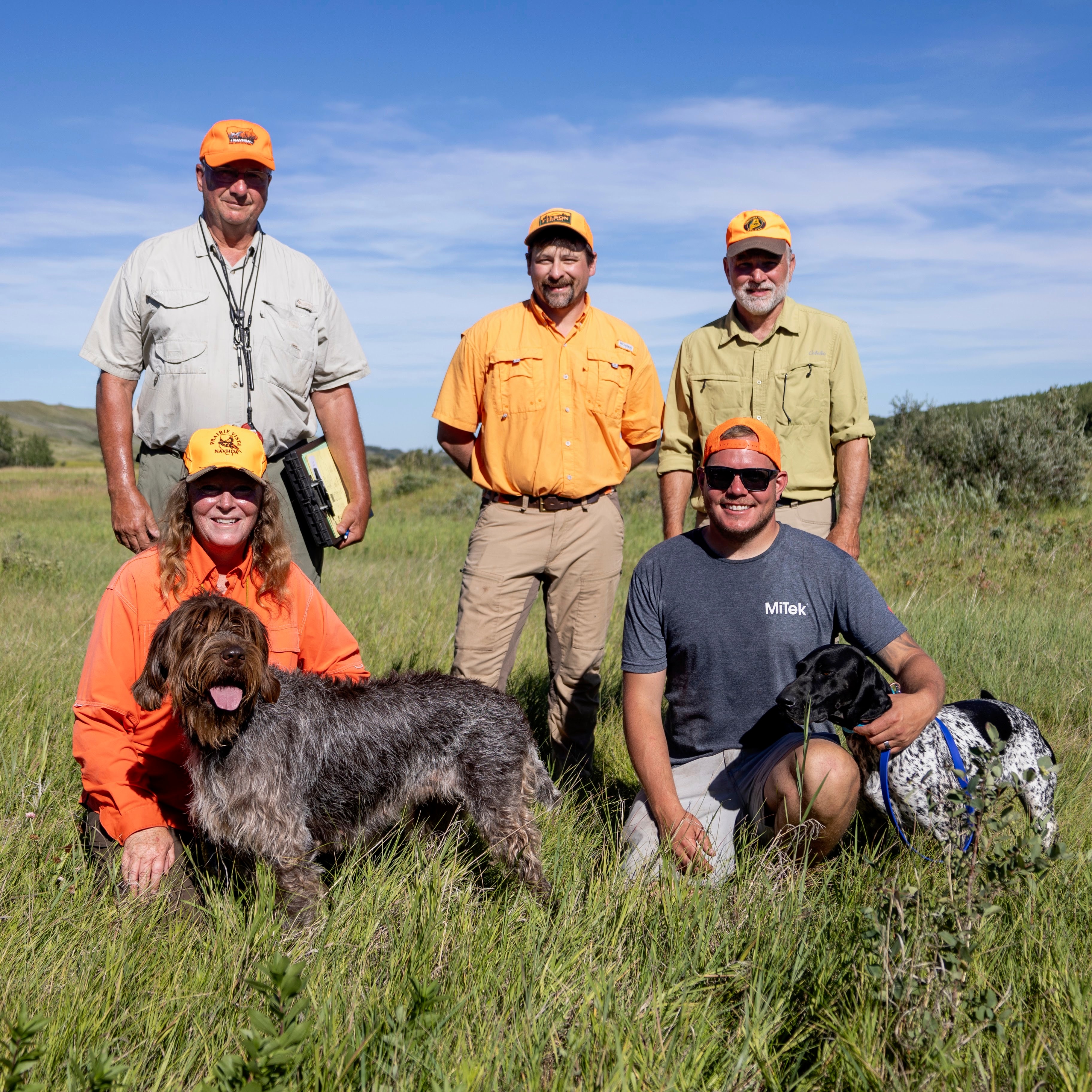 NAVHDA team members with their hunting dogs outdoors
